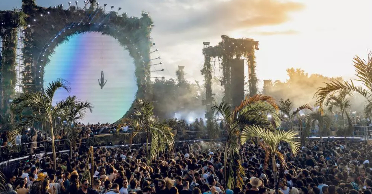 DJ performing at Zamna and Day Zero style event in Tulum with colorful lights over the cenote